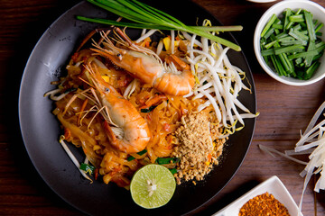 Udon Pad Thai with shrimp in a dark background, top view Asian style food Copy space