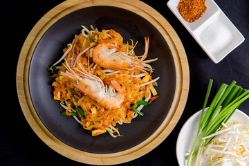 Udon Pad Thai with shrimp in a dark background, top view Asian style food Copy space