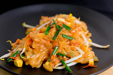 Vegetarian Pad Thai Udon noodles on a black plate Vegetarian Asian style Copy space