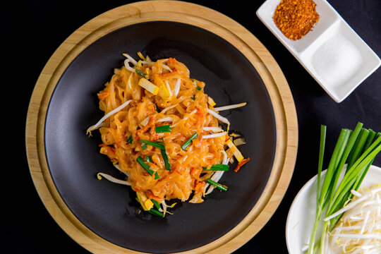 Udon noodles, pad thai, vegetarian vegetables on black plate, top view Asian Vegetarian Copy space