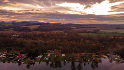Aerial view of several divided ponds in a row during sunset in the area of Hustopece nad Becvou.