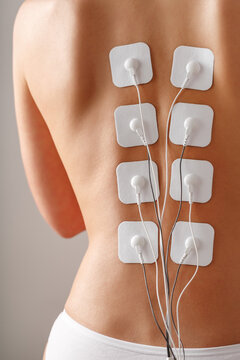 Myostimulation electrodes on a woman's back for massage and rehabilitation.