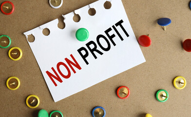 NON PROFIT, text on a sticker on the table, PINNED WITH A BUTTON