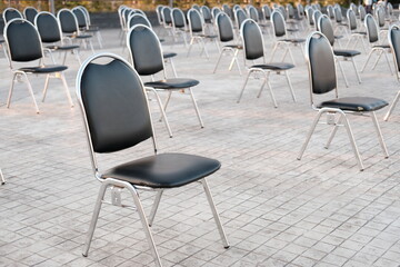 empty black chairs on concrete floor,social distancing