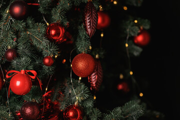 Obraz na płótnie Canvas Red balls decorate a Christmas tree on a green background. Selective focus.