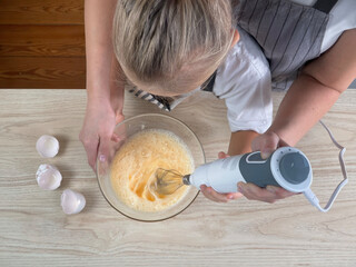 Mother teaching little daughter cooking cake