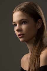 portrait of a beautiful teenage girl with exquisite makeup on a dark gray background