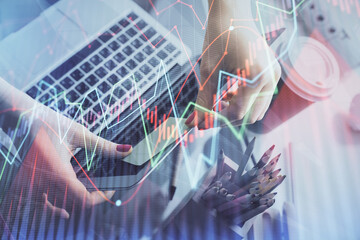 Double exposure of businesswoman hands typing on computer and financial graph hologram drawing. Stock market analysis concept.