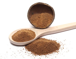 Coconut sugar pile with wooden spoon and shell half isolated on white background