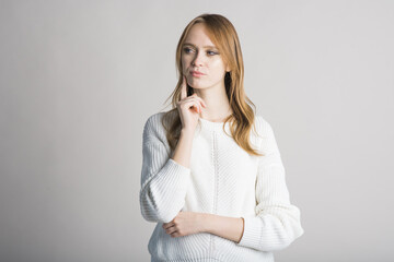 Obraz premium Portrait of a stylish girl on a white background in the studio who thinks