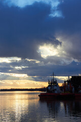 Fototapeta premium Fragment of the ship near the pier against of a colorful sunset over Danube river