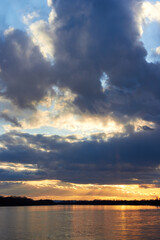 Dramatic sunset cloudy sky over the river at winter season