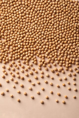 Raw chickpea seeds pile spilled beige surface, border. Natural food background composition. Vegan protein source. Plant extract, nutrient-dense meal. Staple food crop. Agriculture, cultivating legumes