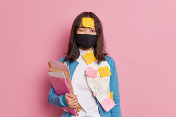 Prevention of virus spread. Serious brunette woman wears black disposable face mask busy doing...
