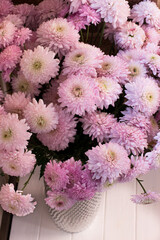 A bouquet of pink chrysanthemums in a vase on a white background view from above