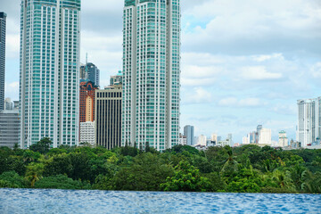Fototapeta premium View of the skyscrapers of the city of Manila from the pool on the high floor. Empty pool without tourists.
