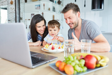 Eltern und Kind essen Kuchen beim Videochat