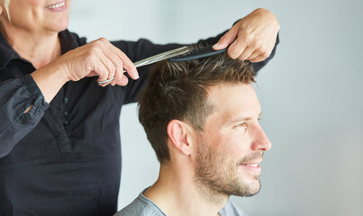 Frau beim Haare schneiden mit Schere beim Friseur