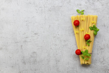A set of products for delicious italian pasta spaghetti with cherry tomatoes and basil. Top view, copy space