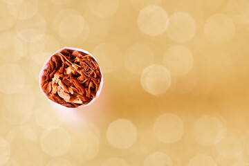 The tip of a cigarette standing on a light shiny background. View from above. Tobacco, cannabinoids...