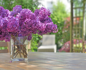 beautiful bouquet of purple lilac flowers on a wooden table in garden