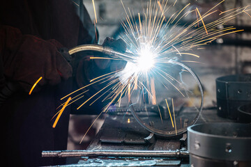 yellow tracks from sparks flying away in the process of welding. Gas metal arc welding - obrazy, fototapety, plakaty
