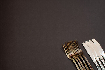 vintage knives and forks on black background