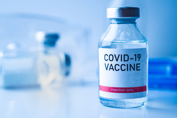 A single bottle vial of Covid-19 vaccine. Medical concept vaccination hypodermic injection...