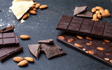 
Chocolate and cocoa concept. Cocoa butter and broken chocolate on black background, top view, copy space