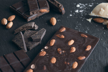 
Raw dark chocolate with nuts on gray background