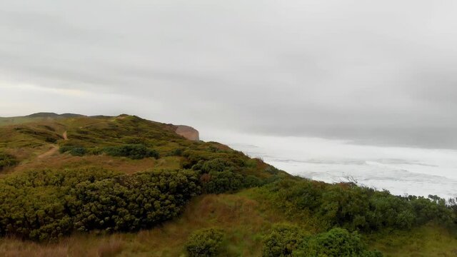 Aerial view of the Twelve Apostles, a collection of limestone stacks off the shore of Port Campbell National Park from Gibson Steps on a cloudy day