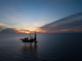 Aerial view offshore drilling rig (jack up rig) at the offshore location during sunset