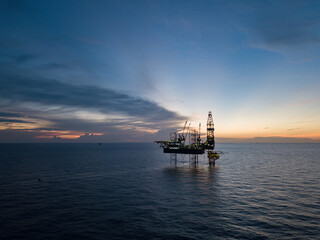 Aerial view offshore drilling rig (jack up rig) at the offshore location during sunset
