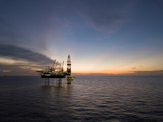 Aerial view offshore drilling rig (jack up rig) at the offshore location during sunset