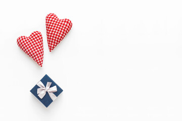 Obraz premium Valentines day composition. Two soft red hearts and gift box on white background. Flat lay, top view, copy space