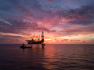 Aerial view offshore drilling rig (jack up rig) at the offshore location during sunset