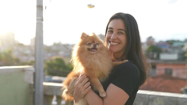 portrait of a happy woman hugging her dog pet and smiling to camera. German Spitz