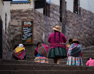 Foto op Canvas Indigenous quechua women in traditional colorful handwoven textile clothing dress costume walking in Cusco Peru © Marc