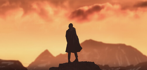 a silhouette girl in peak of winter mountains with golden sunset.