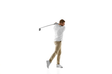 Concentrated. Golf player in a white shirt taking a swing isolated on white studio background with copyspace. Professional player practicing with bright emotions and facial expression. Sport concept.