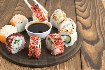 sushi on a plate with chopsticks. on a wooden background. close-up