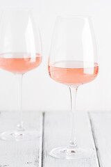 Rose wine in glasses on a white old wooden table. Selective focus. Wine tasting concept.