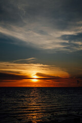 Orange and blue sunset with clouds over the ocean