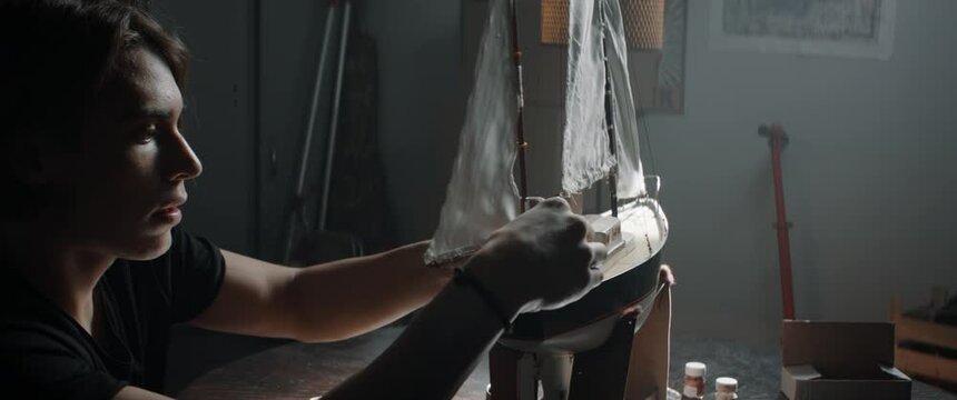CU Portrait of Caucasian teenager boy placing sails on his boat model school project. Shot with 2x anamorphic lens