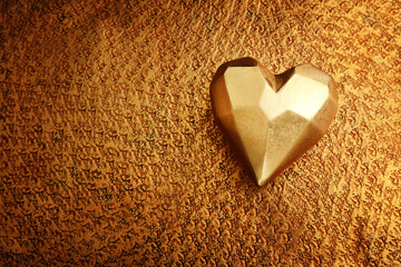 Top view of gold heart over bronze background