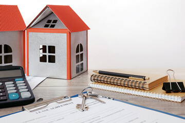 Blank real estate lease agreement, house models on office desk