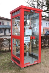 Ancienne cabine téléphonique rouge transformée en point d'échange de livres, ville de Polliat, département de l'Ain, France