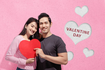 Asian couples holding the red heart with a pink background
