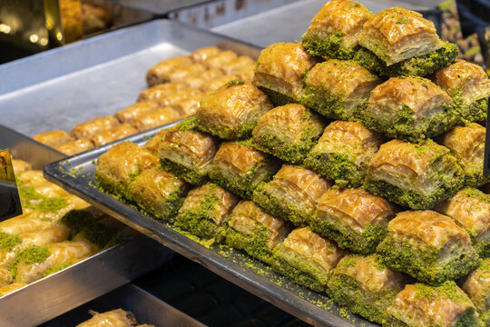 Traditional Turkish baklava with pistachios on the big trays in kitchen.