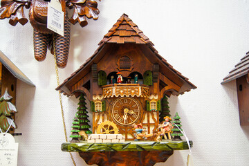 Handcrafted wooden cuckoo clock mounted on a wall.